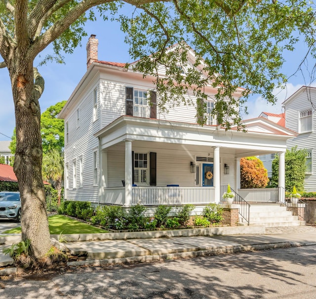 view of front of home with a porch and a chimney