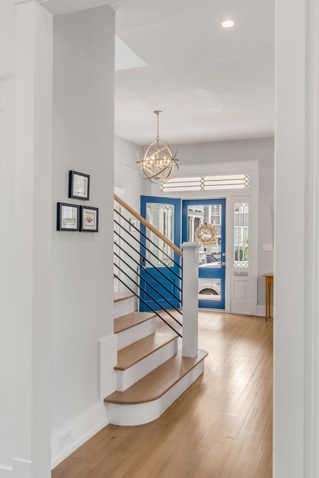 staircase with a notable chandelier, recessed lighting, baseboards, and wood finished floors