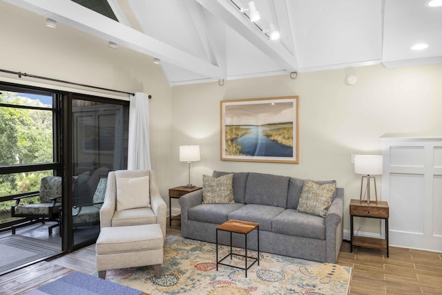 living room with lofted ceiling with beams and light hardwood / wood-style floors