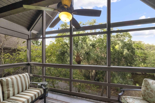 unfurnished sunroom with lofted ceiling with beams and ceiling fan