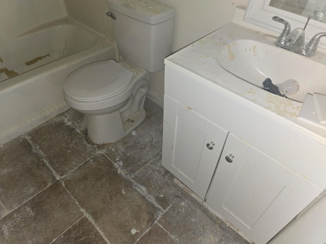 bathroom with vanity, a tub to relax in, and toilet