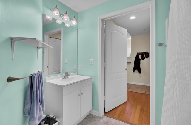 bathroom featuring walk in shower, wood-type flooring, and vanity