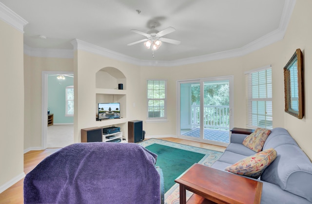 living room featuring ornamental molding, light hardwood / wood-style flooring, ceiling fan, and built in features