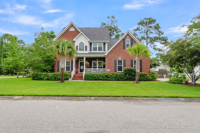 view of front of home with covered porch and a front lawn