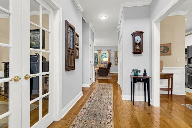 corridor with crown molding, light hardwood / wood-style flooring, and french doors