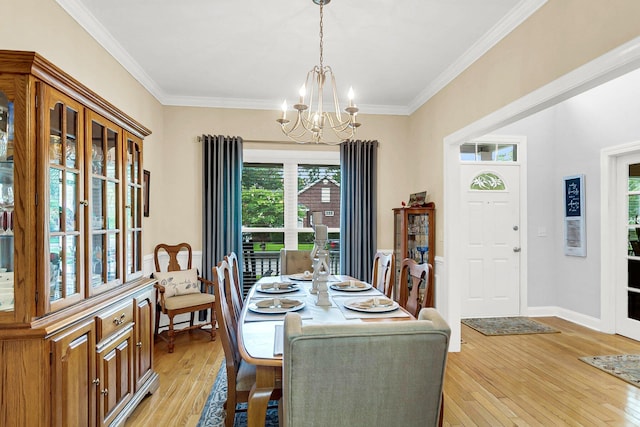 dining area with a notable chandelier, light hardwood / wood-style flooring, and ornamental molding