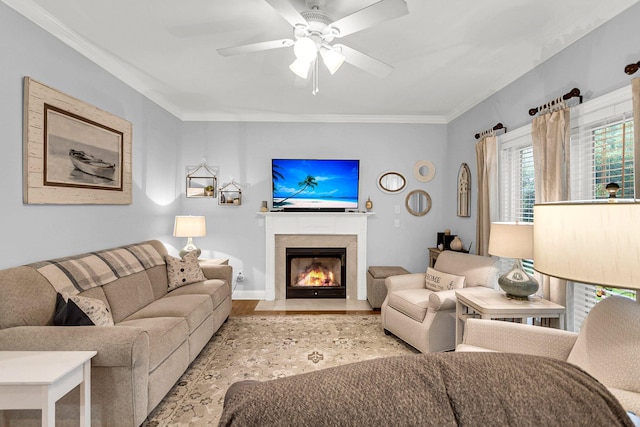 living room with ceiling fan, ornamental molding, and light wood-type flooring