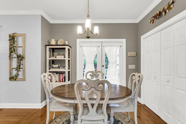 dining room featuring dark hardwood / wood-style flooring, a notable chandelier, crown molding, and french doors