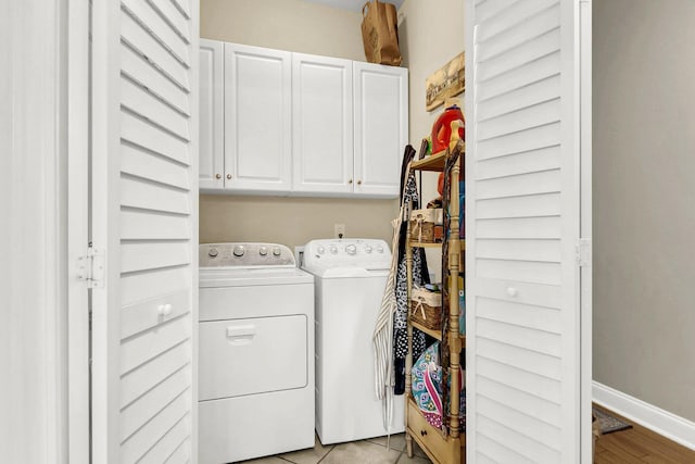 laundry area with washer and clothes dryer and cabinets