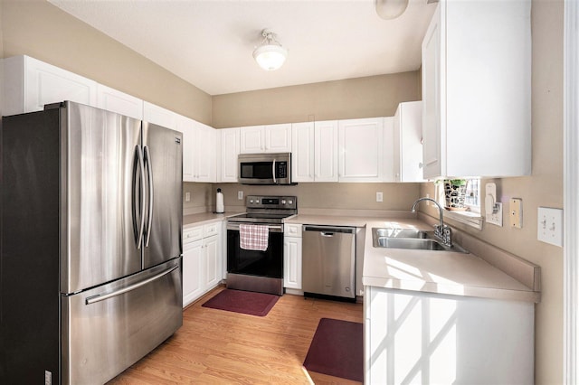 kitchen featuring white cabinets, stainless steel appliances, and a sink