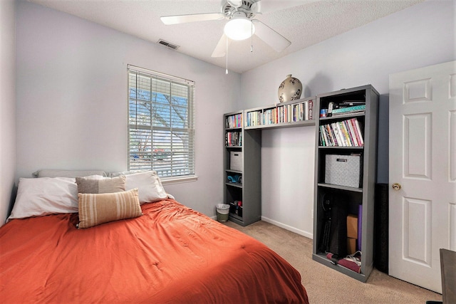 bedroom with ceiling fan, carpet, visible vents, and a textured ceiling