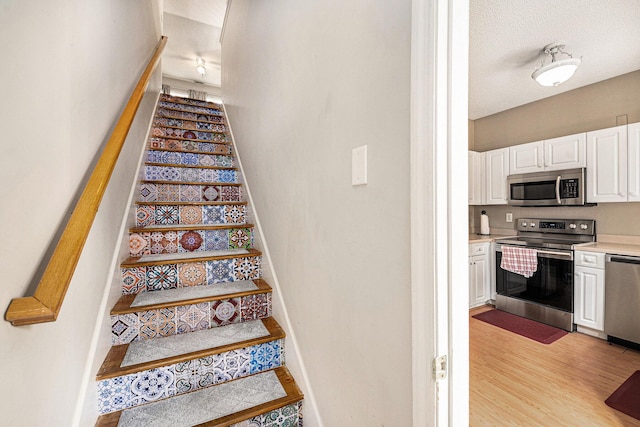 stairs with wood finished floors and baseboards