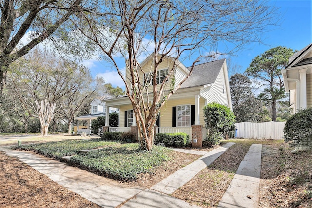 view of front facade with a porch and fence