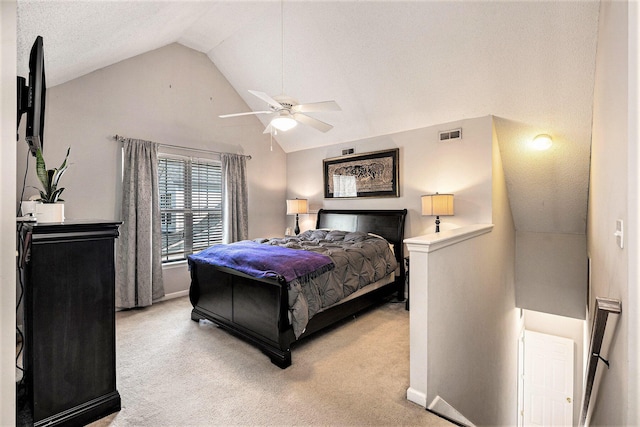 bedroom featuring a ceiling fan, visible vents, lofted ceiling, a textured ceiling, and light colored carpet