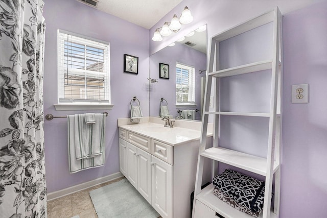 bathroom featuring vanity, visible vents, baseboards, and a textured ceiling