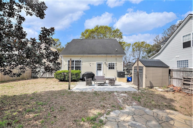 back of house with a patio, a fenced backyard, an outdoor structure, a storage unit, and a lawn