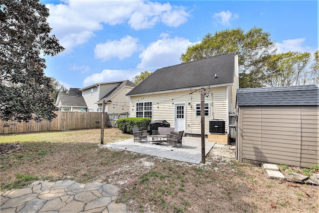 back of house featuring an outbuilding, a fenced backyard, central AC, a storage unit, and a patio area