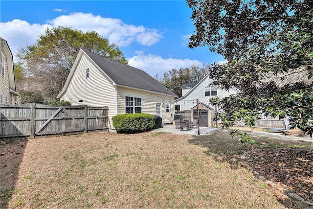 back of property with a yard, a patio area, and fence