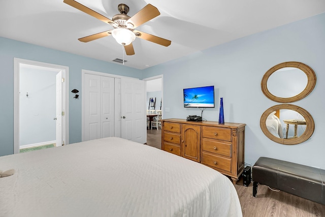 bedroom with ceiling fan, a closet, and light hardwood / wood-style flooring