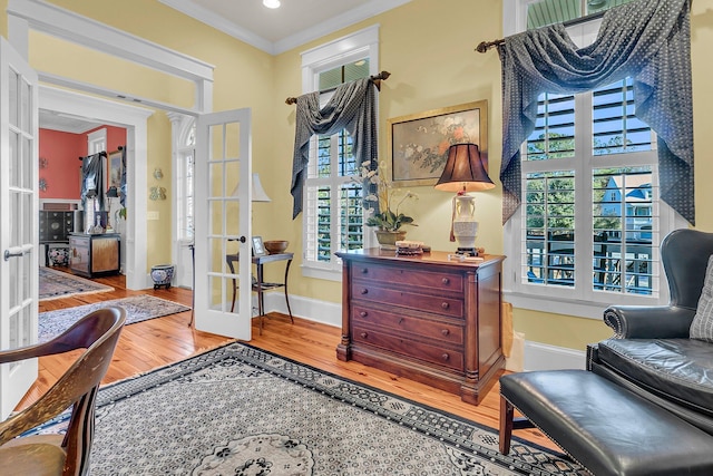 sitting room featuring hardwood / wood-style flooring, crown molding, a wealth of natural light, and french doors