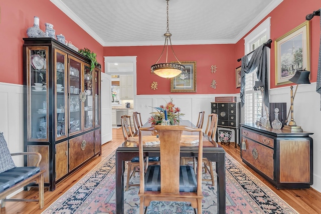 dining space with crown molding and light wood-type flooring