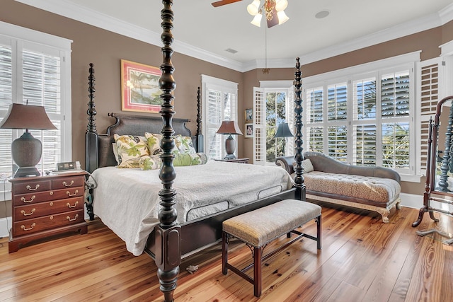 bedroom with ceiling fan, ornamental molding, hardwood / wood-style floors, and multiple windows