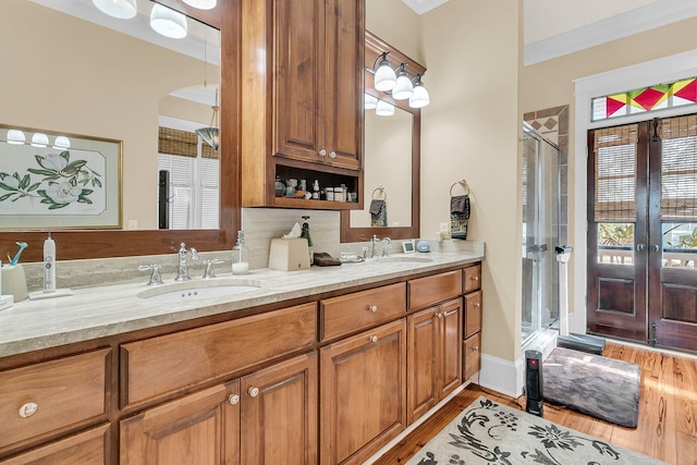 bathroom with hardwood / wood-style flooring, vanity, crown molding, and a shower with shower door