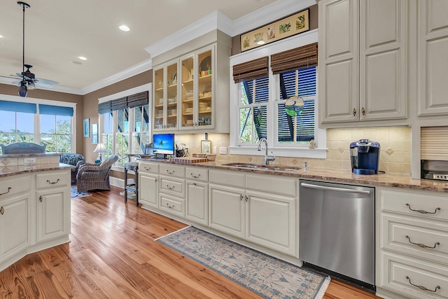 kitchen featuring tasteful backsplash, dishwasher, sink, and white cabinets