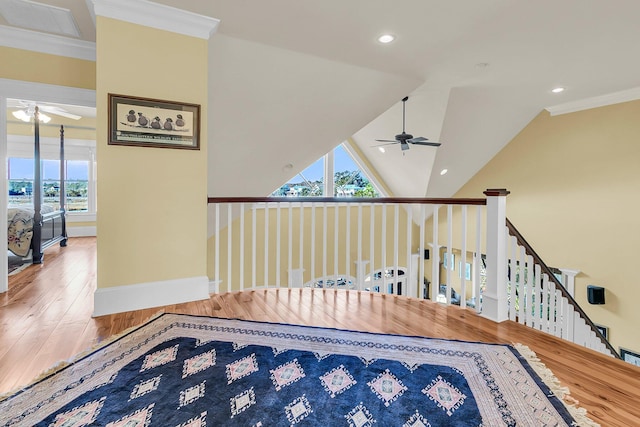 stairway featuring lofted ceiling, a healthy amount of sunlight, crown molding, and ceiling fan