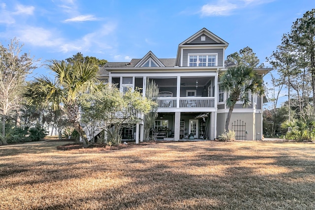 rear view of house with a lawn and a sunroom