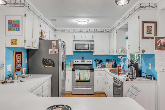 kitchen with stainless steel appliances, white cabinetry, and sink