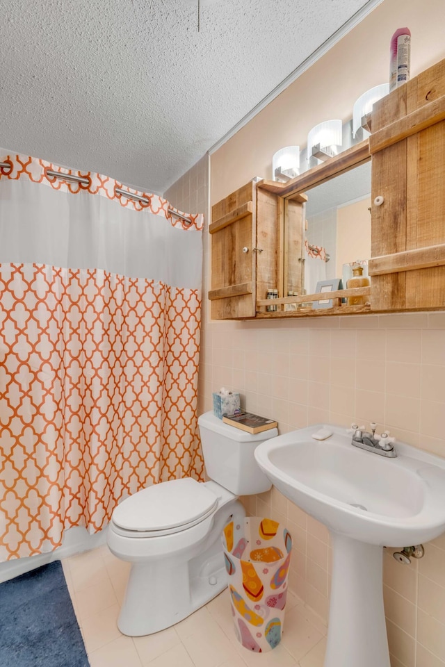 bathroom with tile walls, decorative backsplash, toilet, tile patterned floors, and a textured ceiling