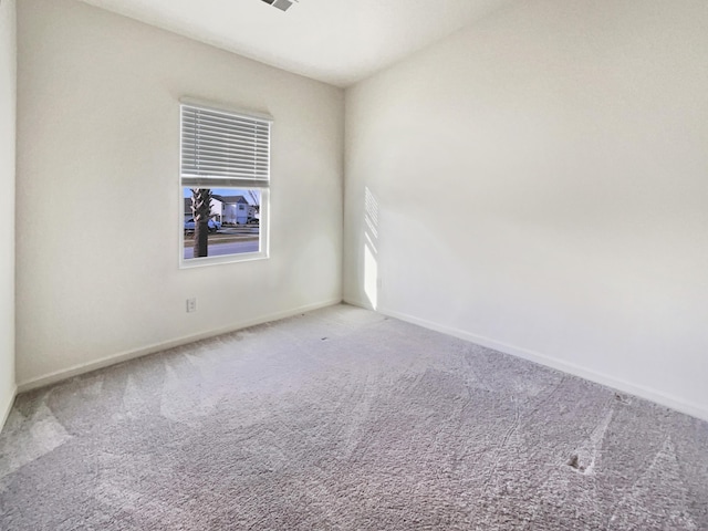 carpeted spare room with baseboards