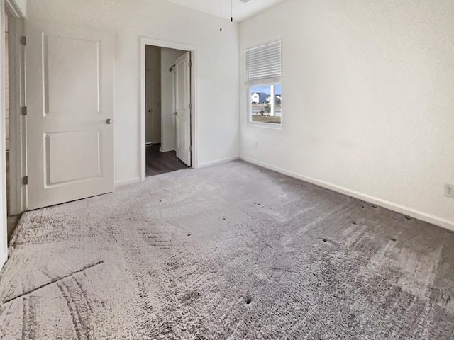 unfurnished bedroom featuring carpet flooring and baseboards