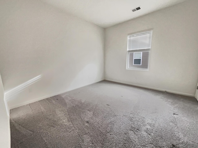 carpeted empty room featuring visible vents and baseboards