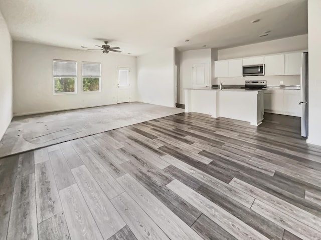 unfurnished living room with wood finished floors and a ceiling fan