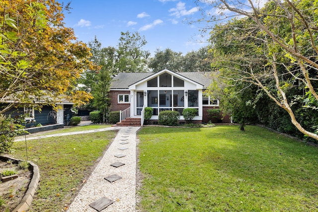 view of front of home featuring a sunroom and a front lawn