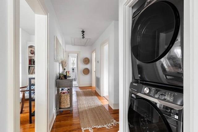 clothes washing area with stacked washer / dryer and hardwood / wood-style floors