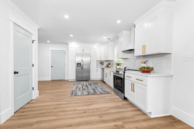 kitchen featuring premium range hood, backsplash, appliances with stainless steel finishes, white cabinets, and light wood-type flooring