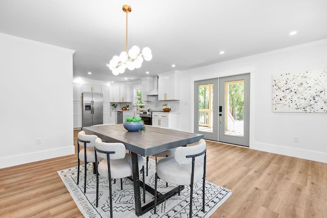 dining room with french doors, ornamental molding, sink, light hardwood / wood-style flooring, and a chandelier