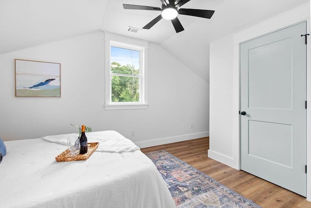 bedroom featuring ceiling fan, hardwood / wood-style floors, and vaulted ceiling