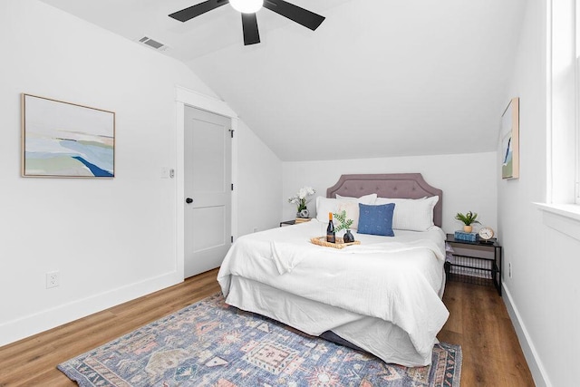 bedroom with ceiling fan, dark hardwood / wood-style floors, and vaulted ceiling