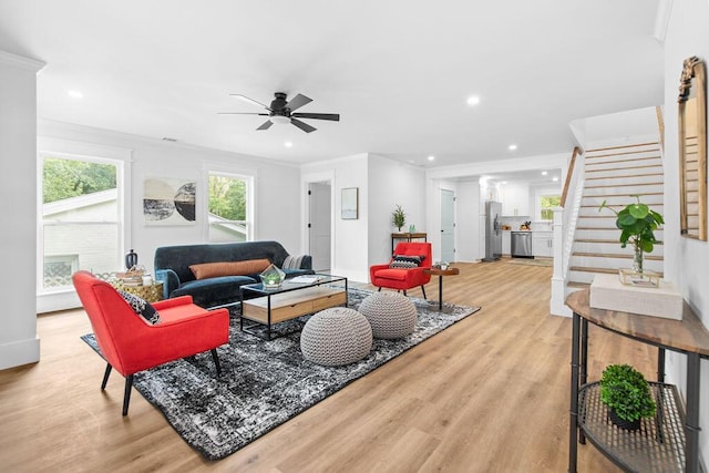 living room featuring ceiling fan, light hardwood / wood-style flooring, and ornamental molding