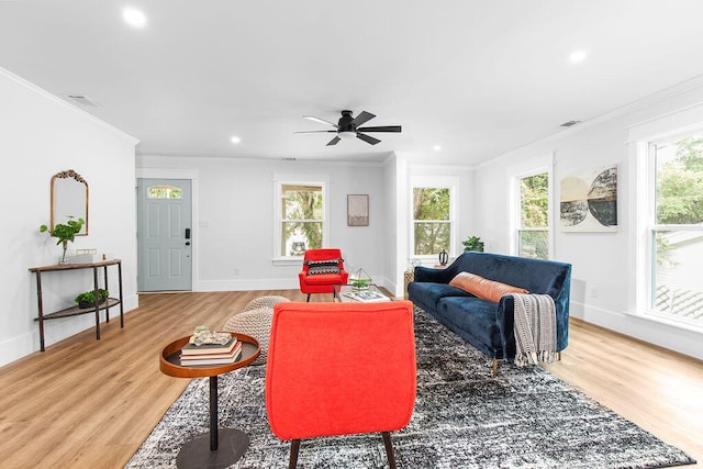 living room with hardwood / wood-style flooring, ceiling fan, and ornamental molding