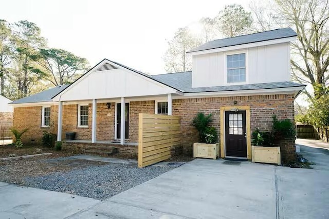 view of front of home featuring brick siding and a porch