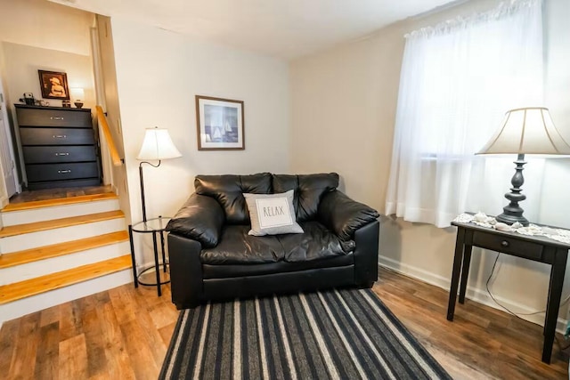 living room with stairs, baseboards, and wood finished floors