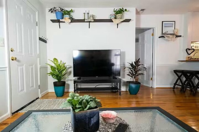 living area with baseboards and wood finished floors