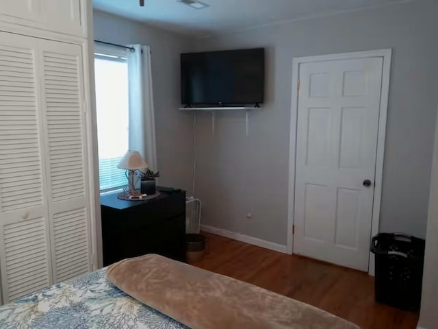 bedroom featuring a closet, baseboards, and wood finished floors