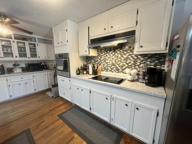 kitchen featuring under cabinet range hood, black appliances, dark wood finished floors, and white cabinetry