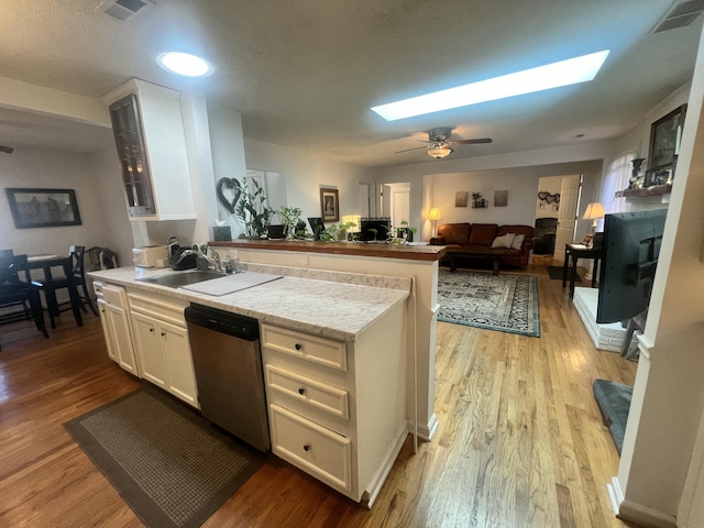 kitchen with dishwasher, a skylight, visible vents, and a sink